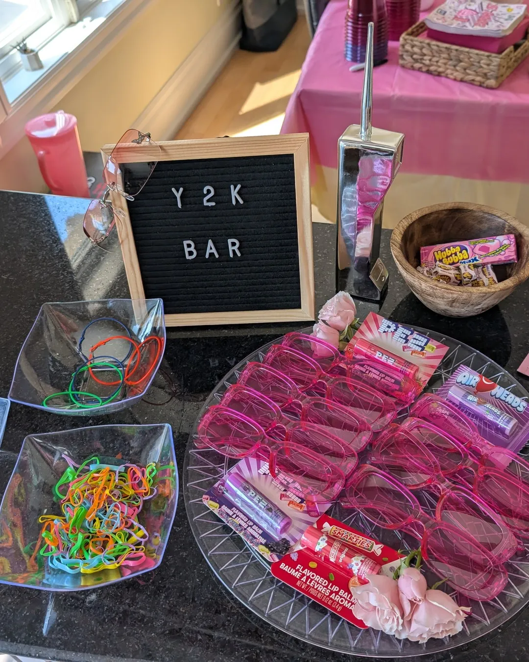 Candy bar with a "Y2K bar" letter board, jelly bracelets, pink sunglasses and retro sweets