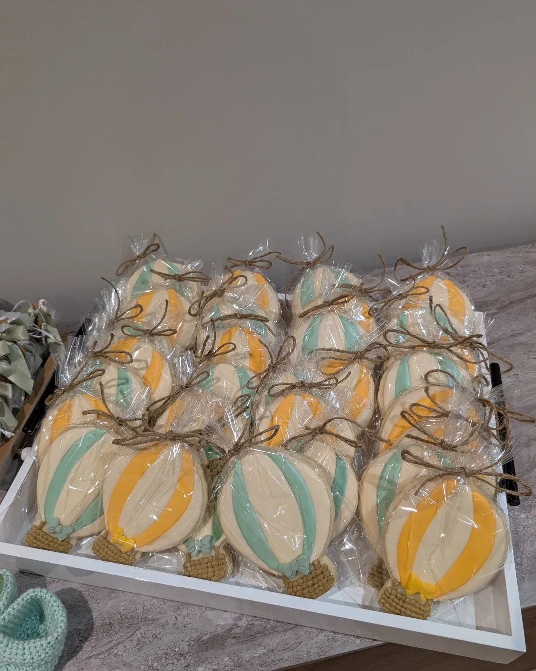 Tray of hand-iced hot-air-balloon cookies in sage and yellow