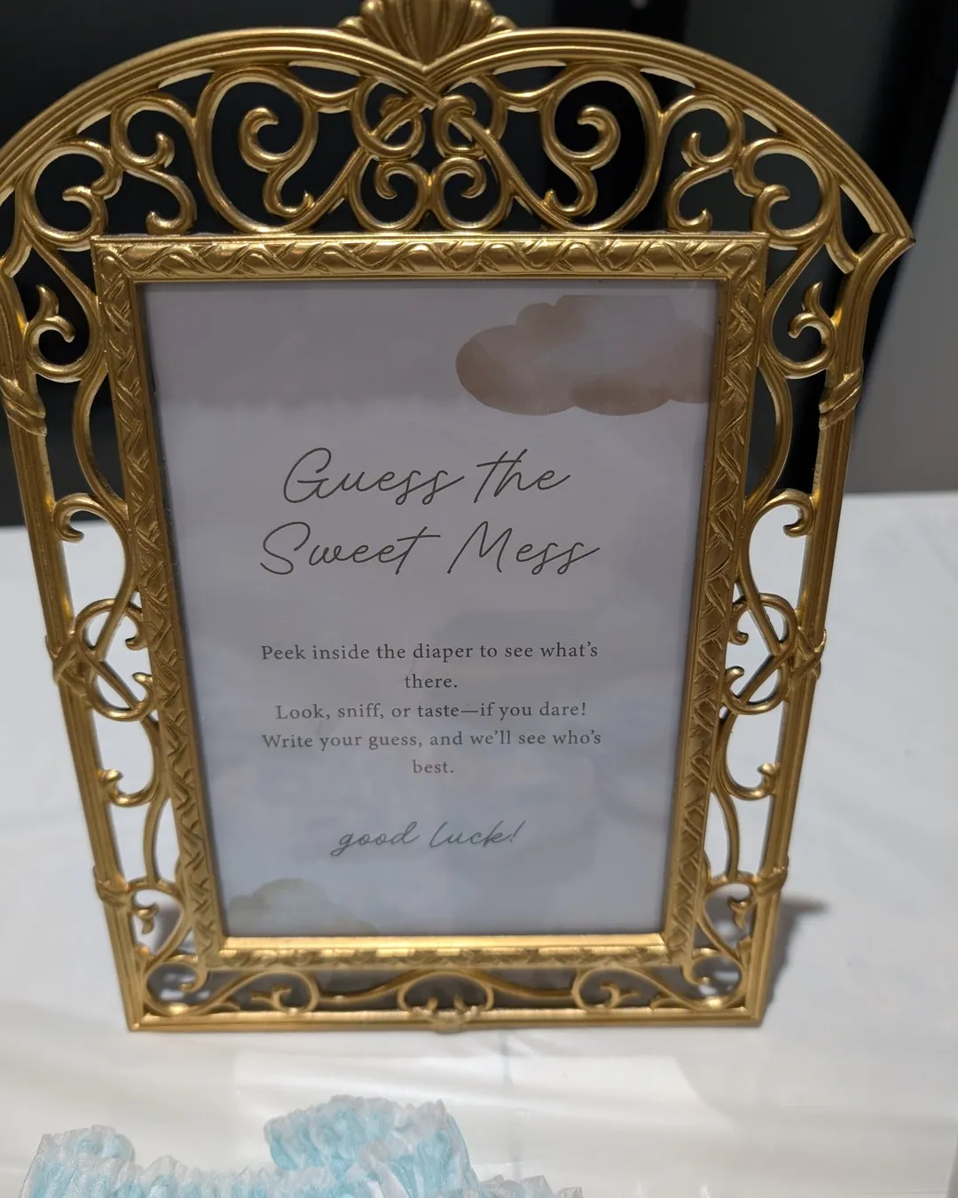 Ornate gold-framed sign for a shower game called "Guess the sweet mess"