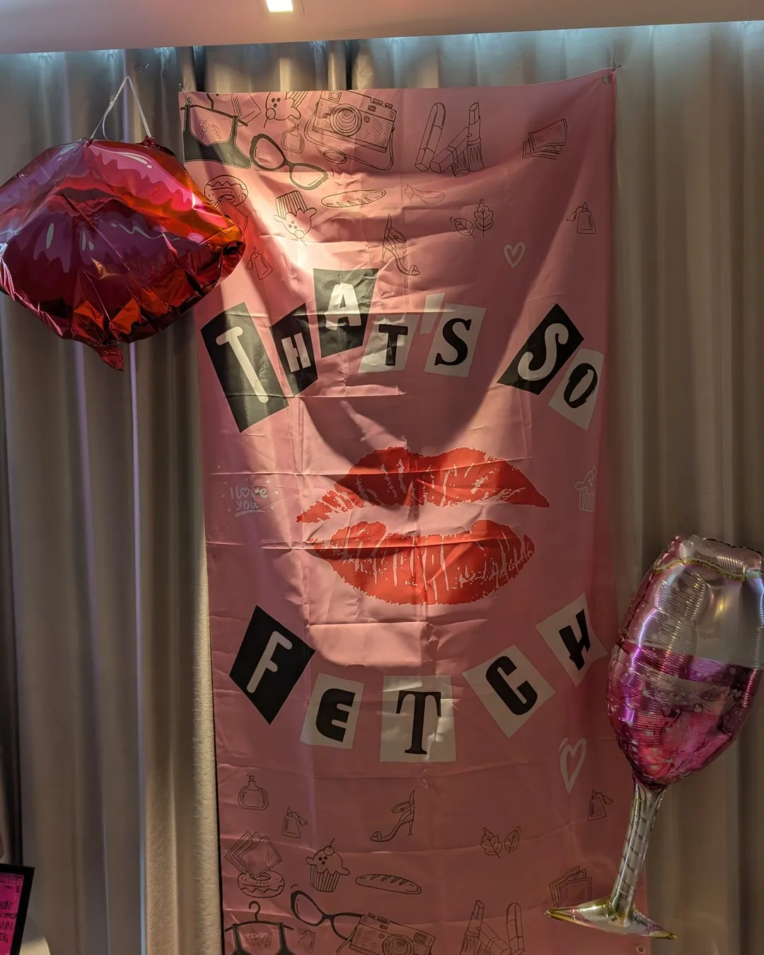 Pink "That's so fetch" wall banner with lip prints, a red heart balloon and a wine-glass balloon